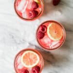 three jars of raspberry lemonade on marble surface