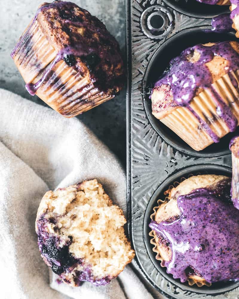 blueberry jam muffins in tin and on marble surface with linen napkin