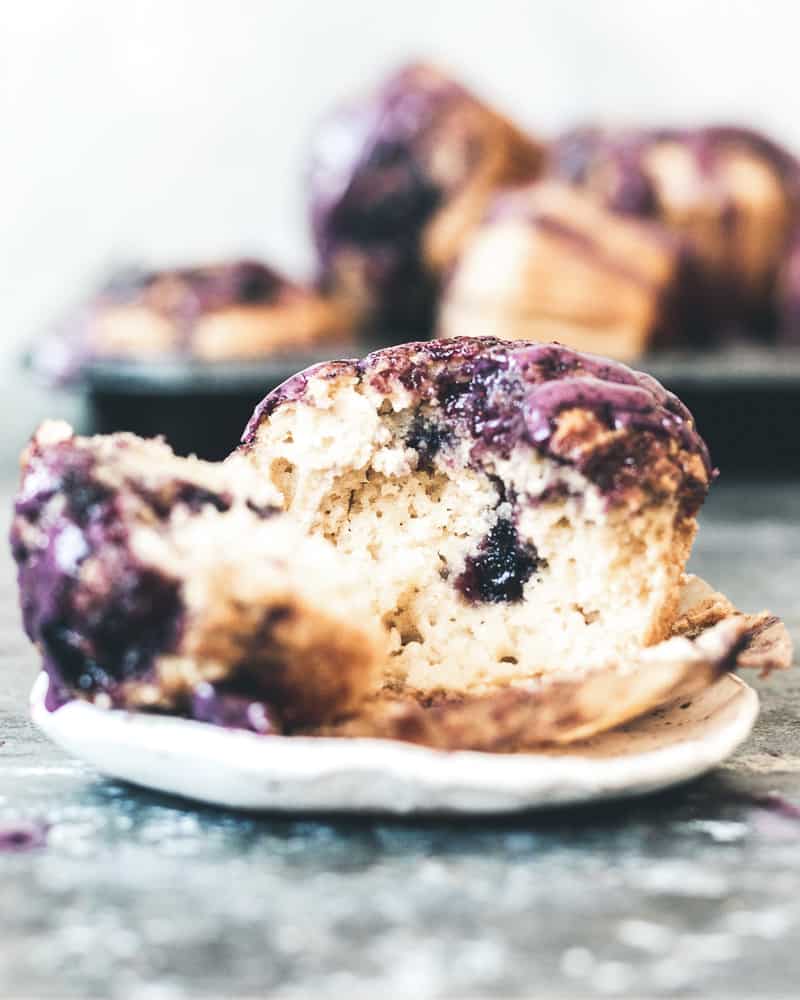 blueberry jam muffin split open on small white plate