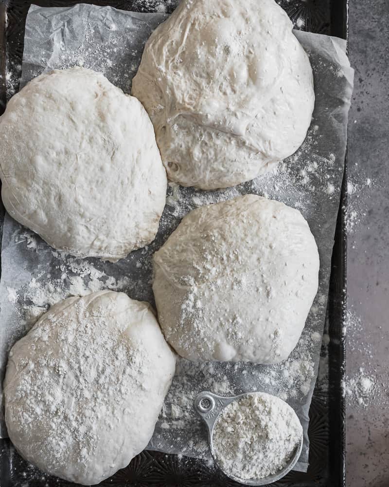 sourdough pizza crust dough balls on baking tray