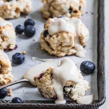 glazed scones on baking tray with blueberries