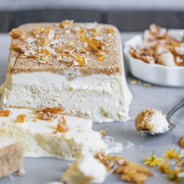 semifreddo sliced on marble surface with spoons and crumbled almond brittle