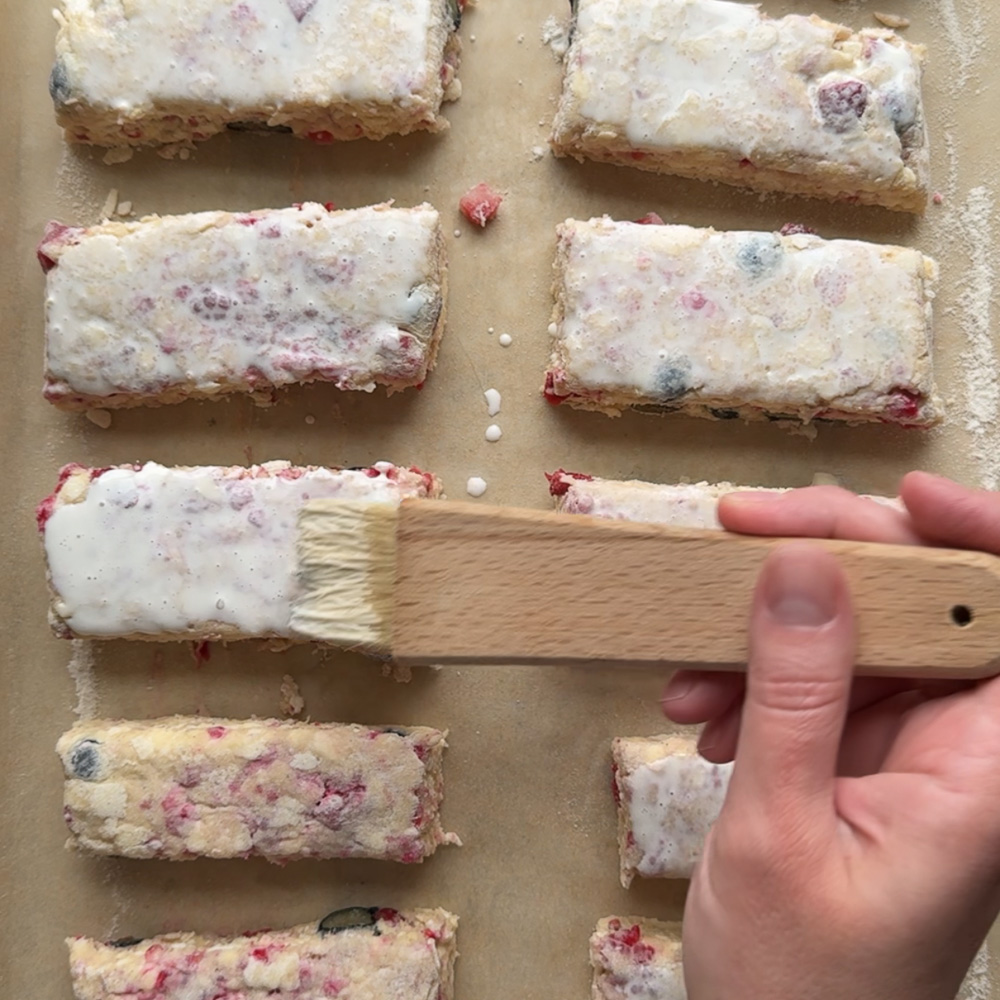 scones being brushed with cream