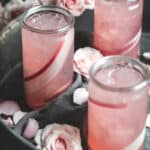 3 rhubarb cocktails in a metal tray with pink roses