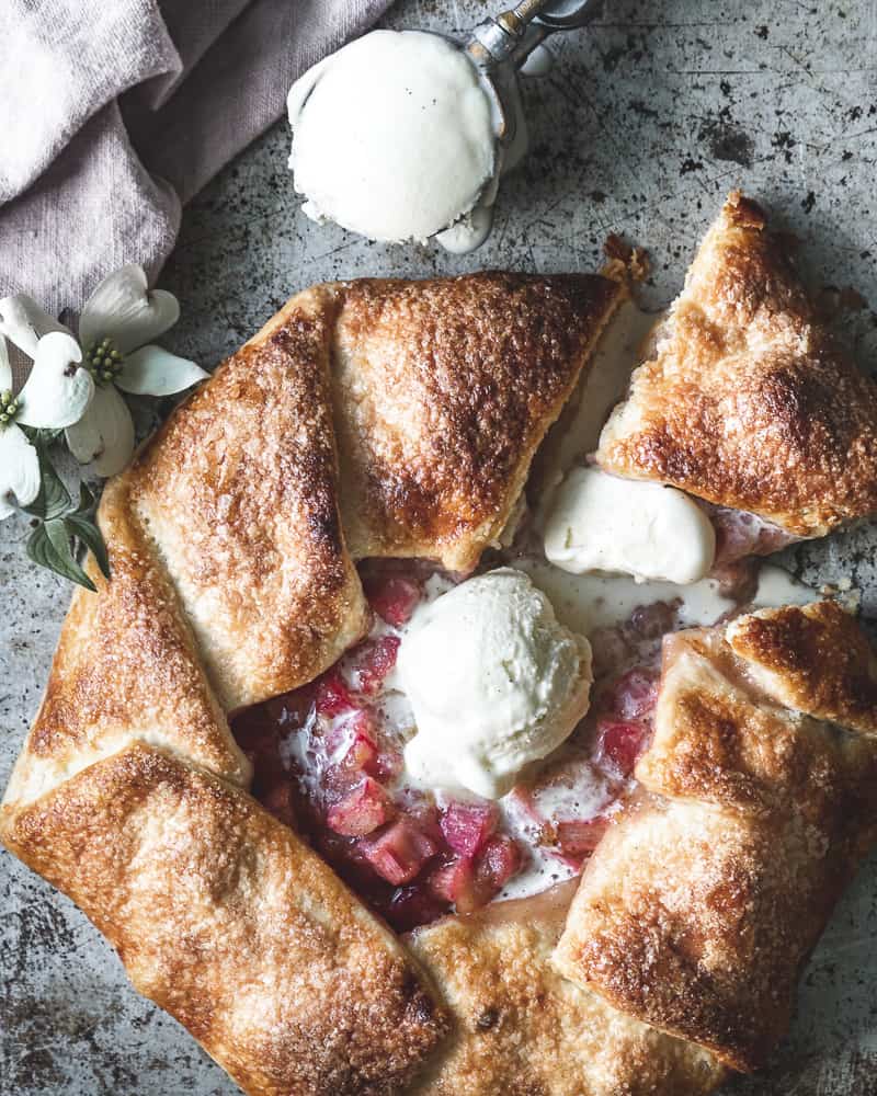 rhubarb galette topped with vanilla ice cream on rustic baking sheet