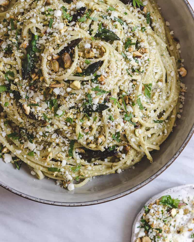 roasted asparagus pesto linguine in large bowl topped with cheese and herbs