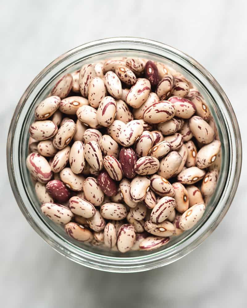 overhead view of dried cranberry beans in a glass jar