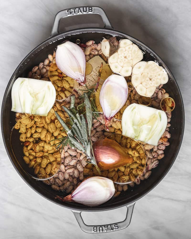 overhead of pot of beans and ingredients before cooking