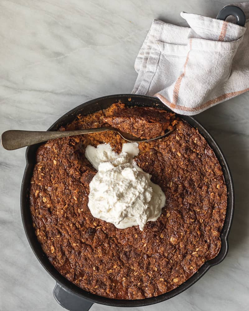 pumpkin crisp in cast iron skillet topped with whipped cream