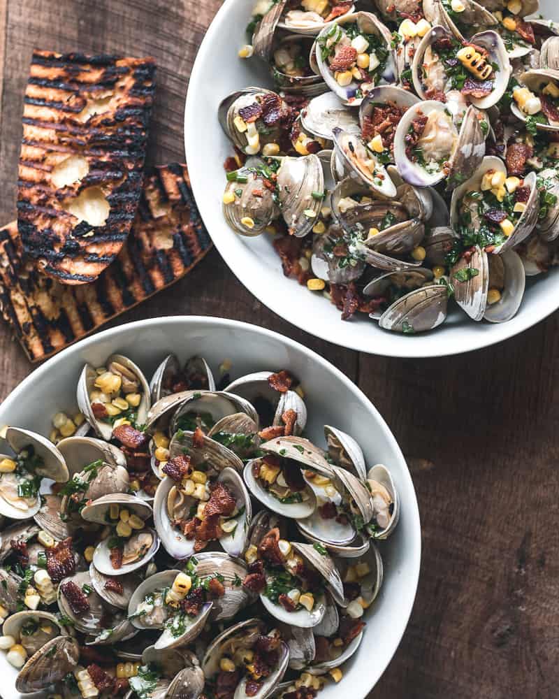 Two large bowls of garlic butter steamed clams with grilled bread