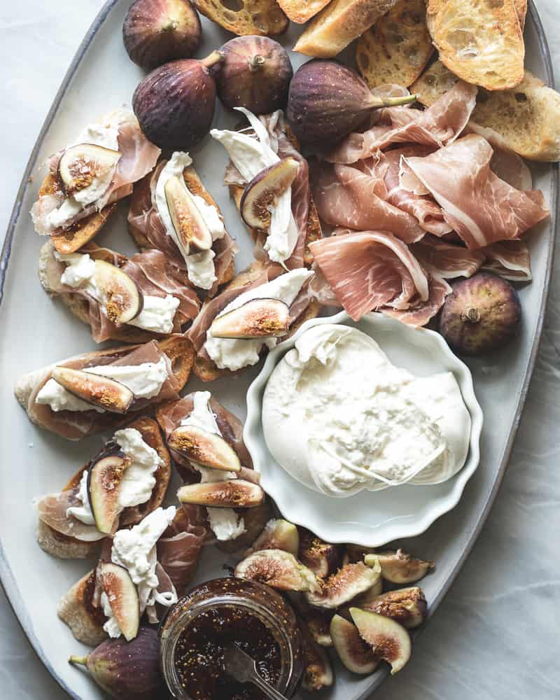fig, burrata, prosciutto crostini assembled on large platter