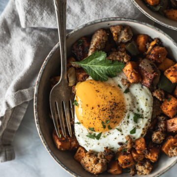 breakfast hash in bowl topped with sunny side up egg