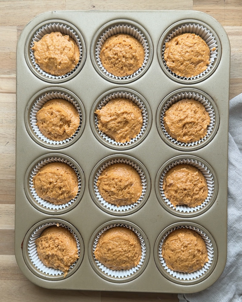 muffin batter scooped into muffin tin