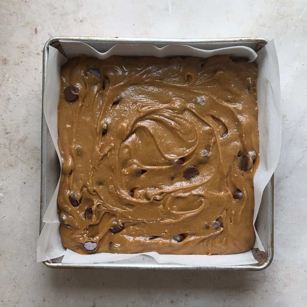 blondie batter added to parchment lined metal baking pan