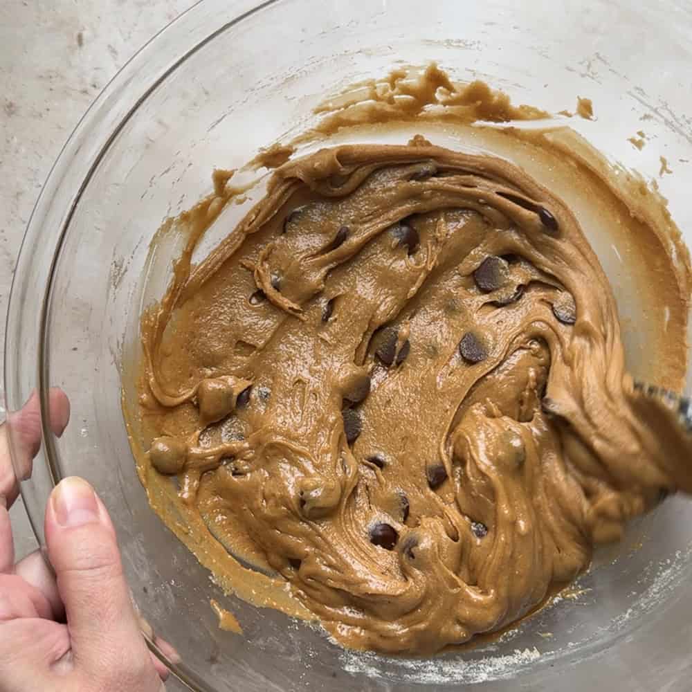 sourdough discard blondie dough fully mixed together with chocolate chips in glass bowl