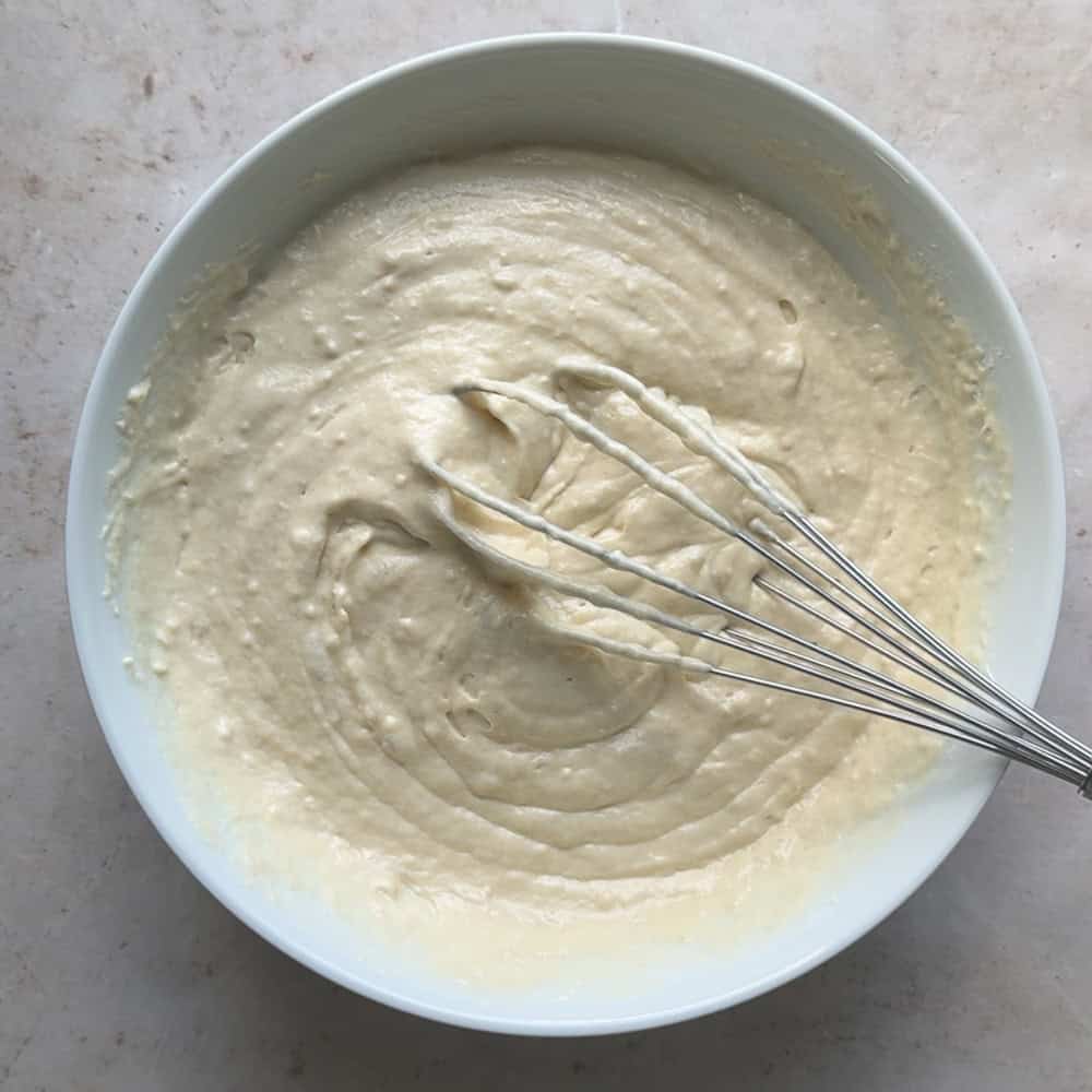waffle batter whisked together in white mixing bowl