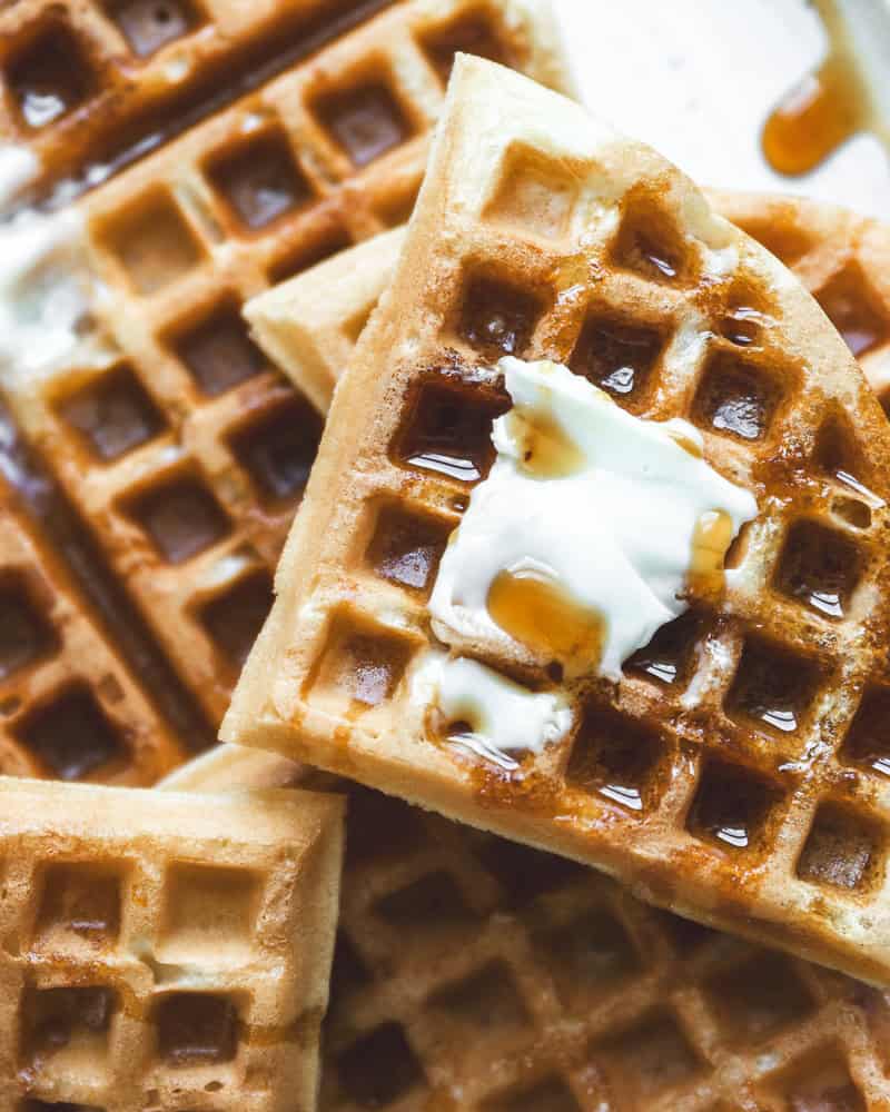 close up of waffles topped with butter and syrup