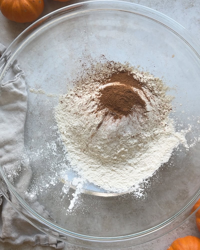 dry ingredients including flour, leaveners, and pumpkin spice in a large glass bowl