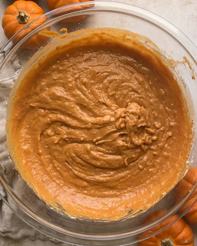 pumpkin bread batter stirred together in a large glass mixing bowl