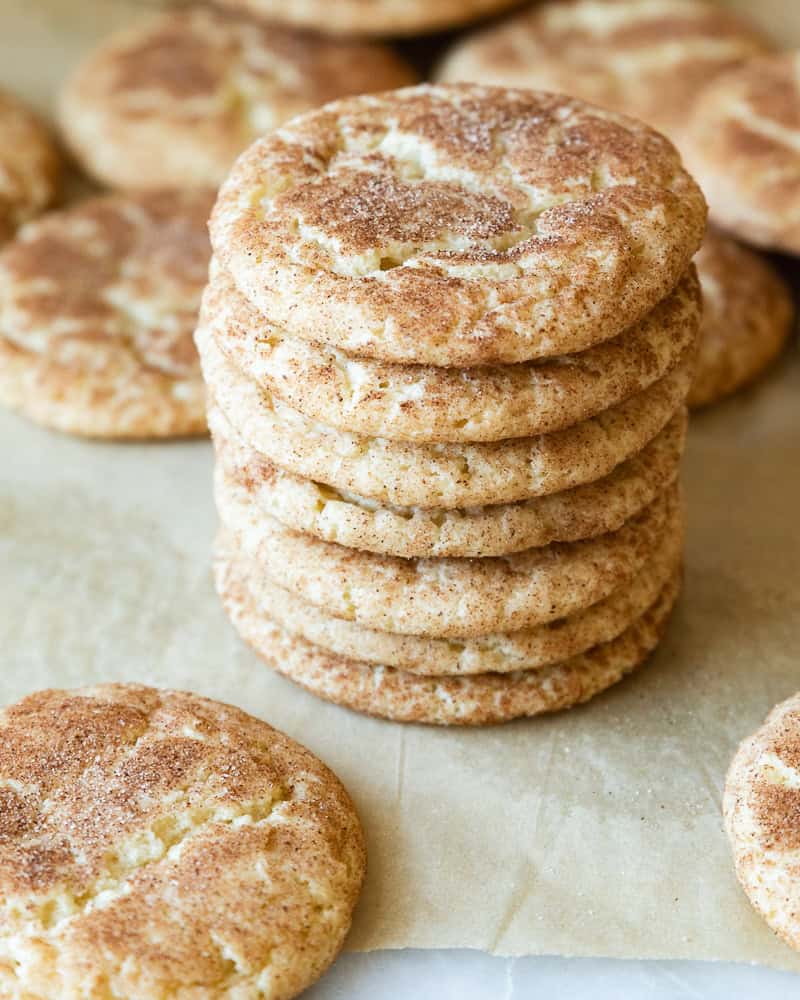 a stack of snickerdoodle cookies surrounded by more cookies