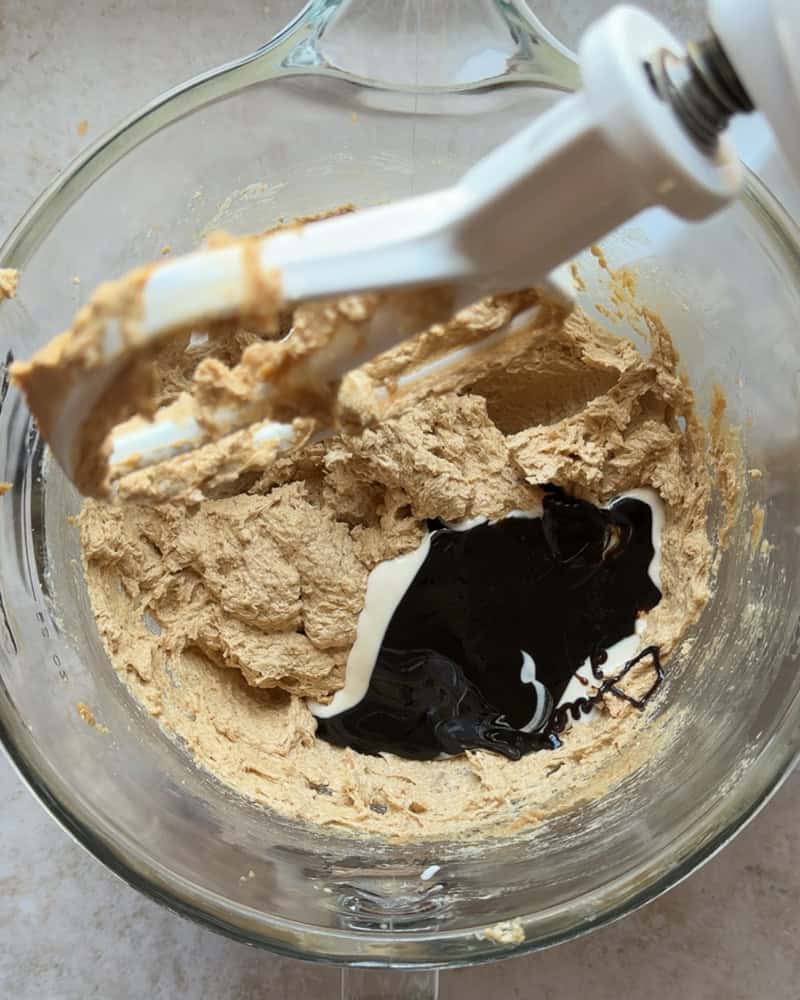 molasses and sourdough starter added to wet mixture in glass bowl of stand mixer