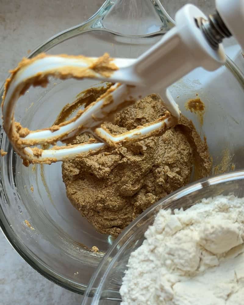 flour being added to wet ingredients in stand mixer