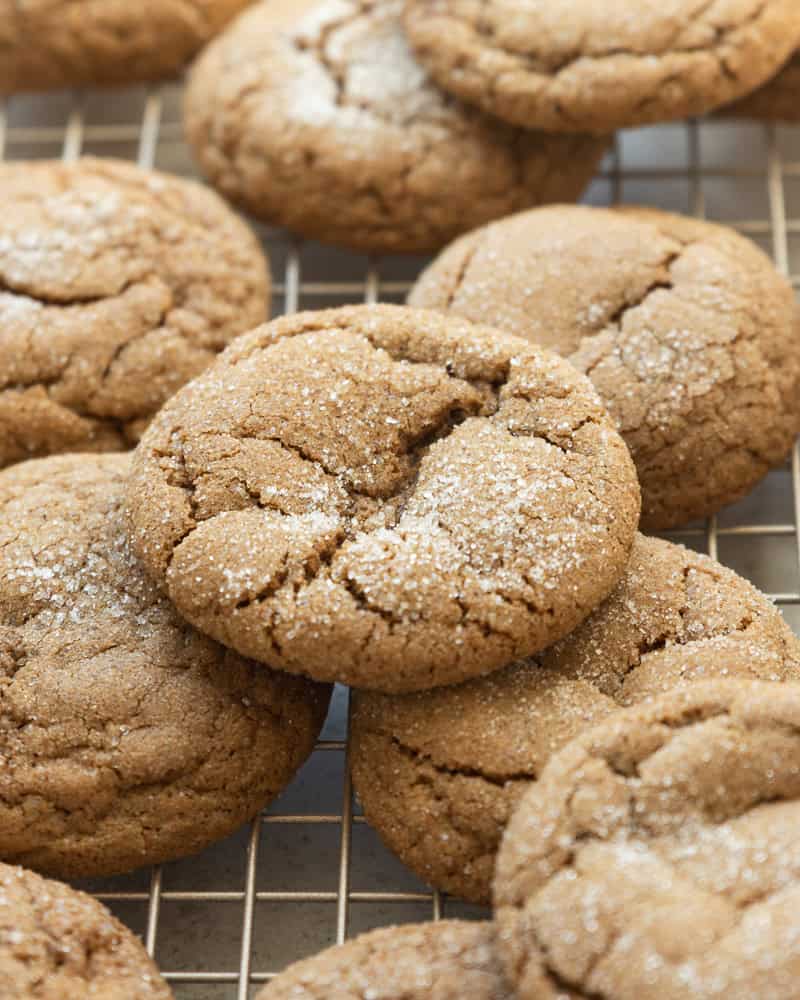 a pile of ginger molasses cookies on a cooling rack