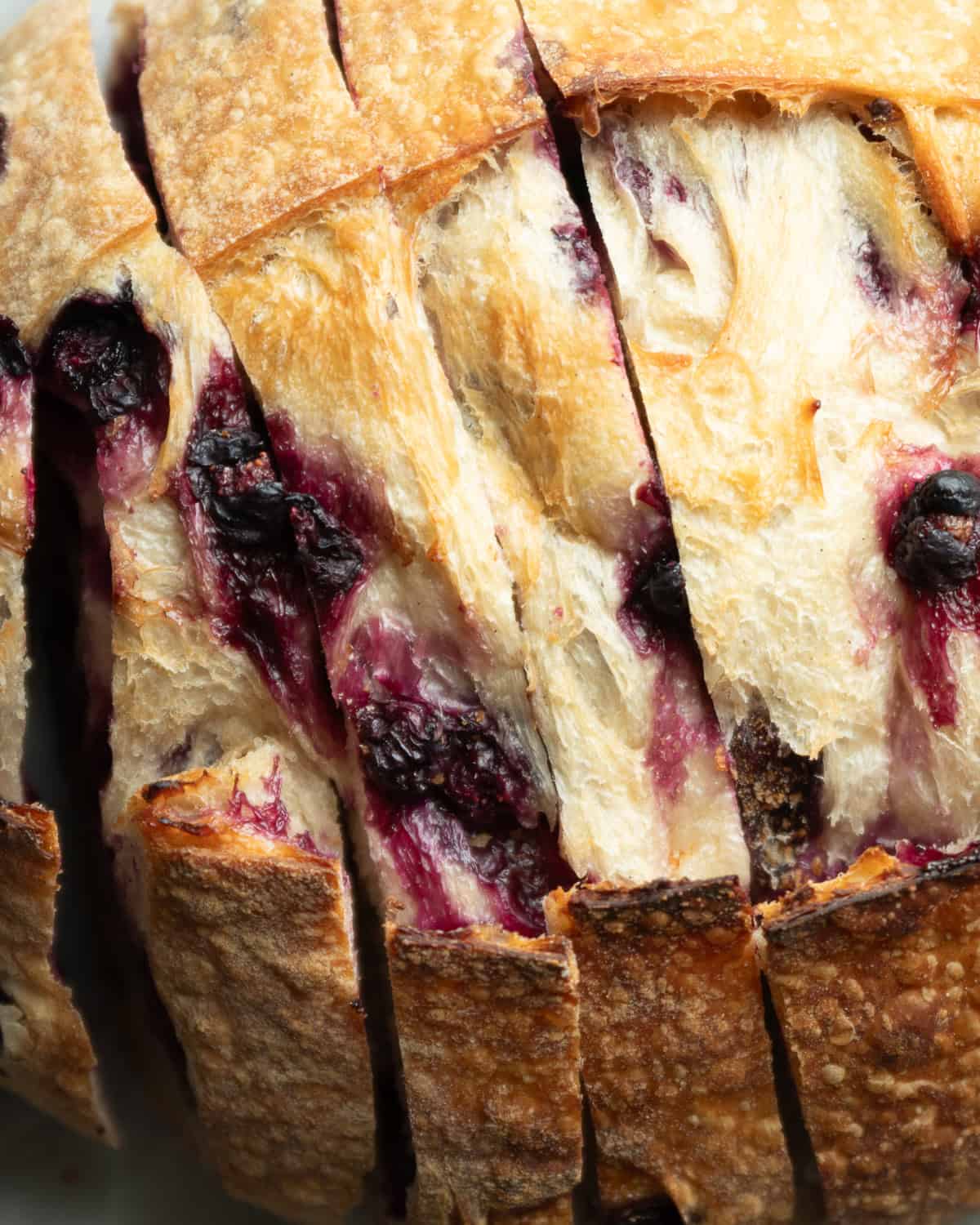 close up of top of sliced blueberry bread loaf