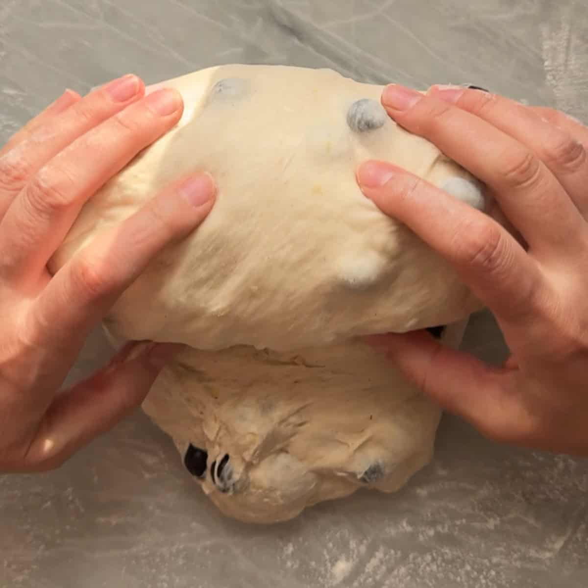 dough being rolled by hand to create a batard loaf shape