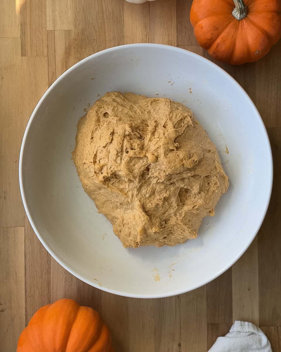 pumpkin colored dough in white bowl