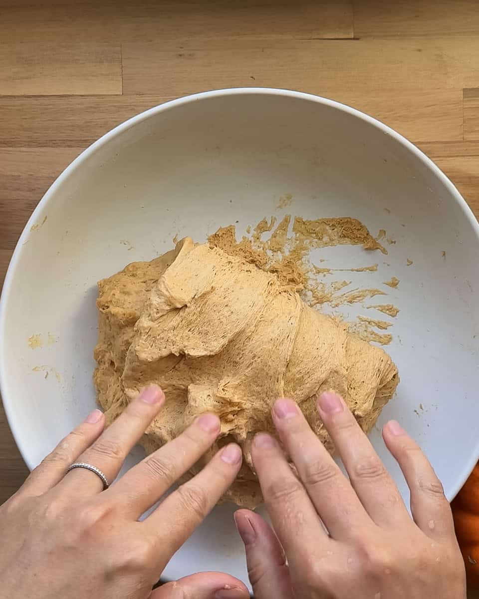Dough being folded back down over itself to complete stretch and fold