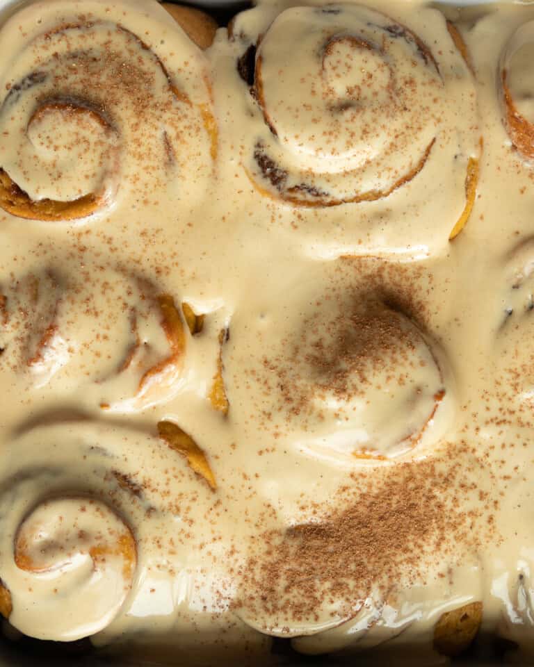 cinnamon rolls covered in frosting and dusted with cinnamon