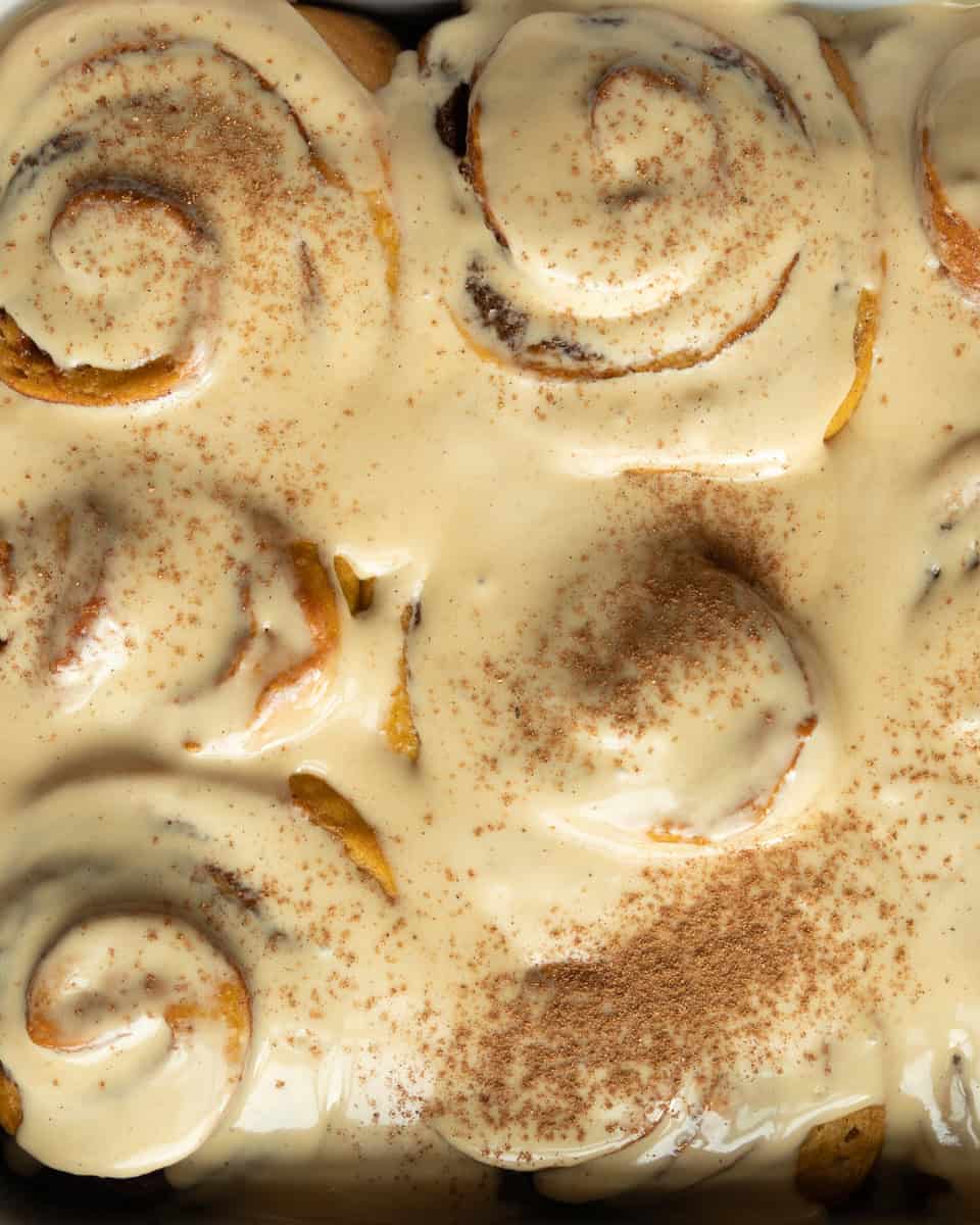 cinnamon rolls covered in frosting and dusted with cinnamon