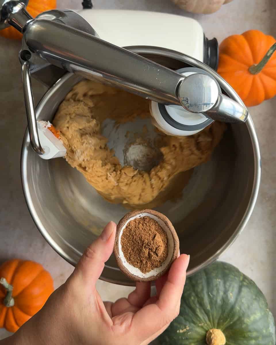 Pumpkin Spice being added to dough in mixing bowl